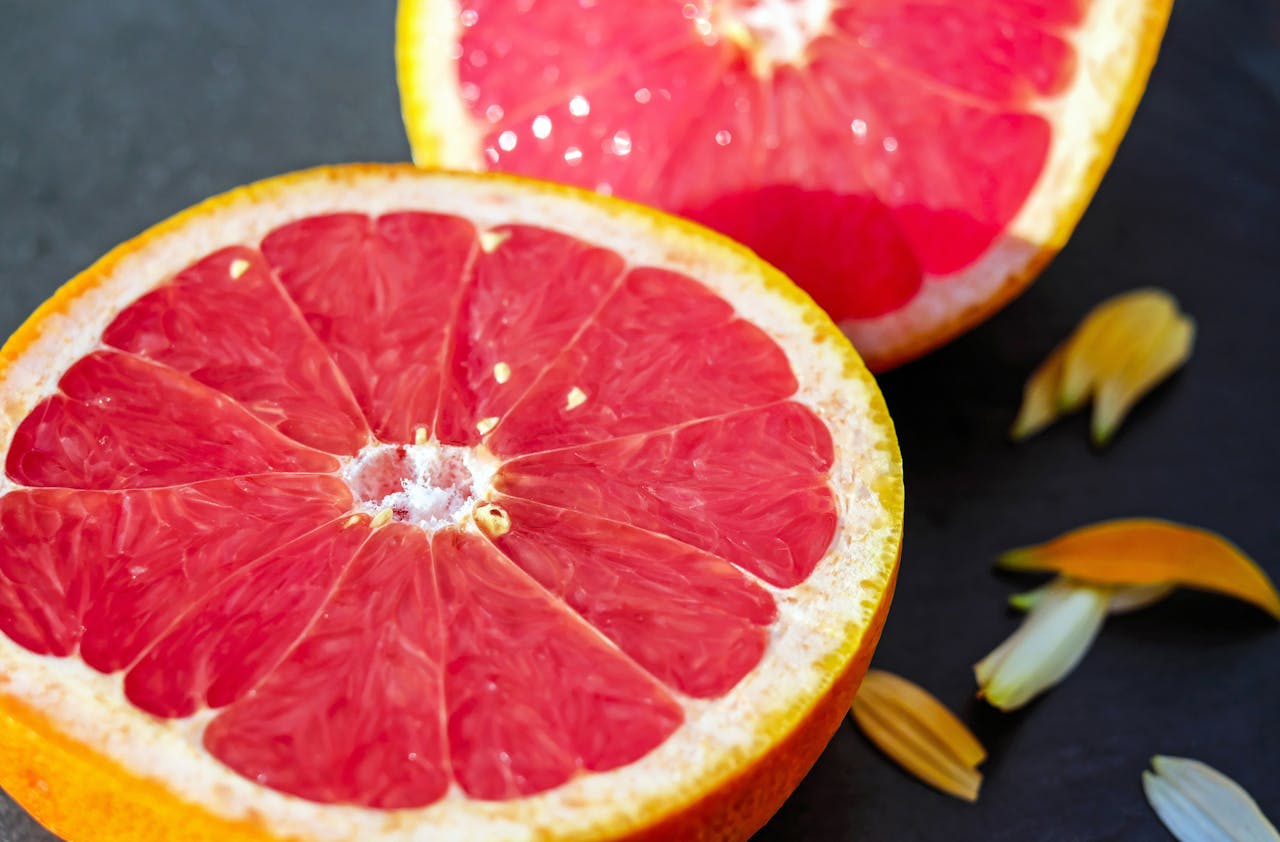 Close-up of juicy grapefruit halves showcasing vibrant red pulp on a dark background.